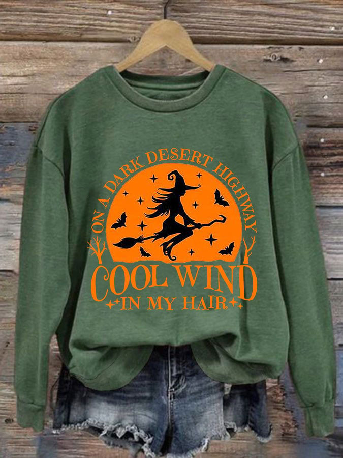 Green sweatshirt with flying witch and orange midnight sky graphic