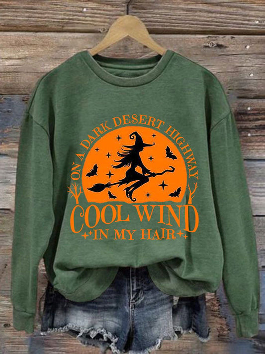Green sweatshirt with flying witch and orange midnight sky graphic