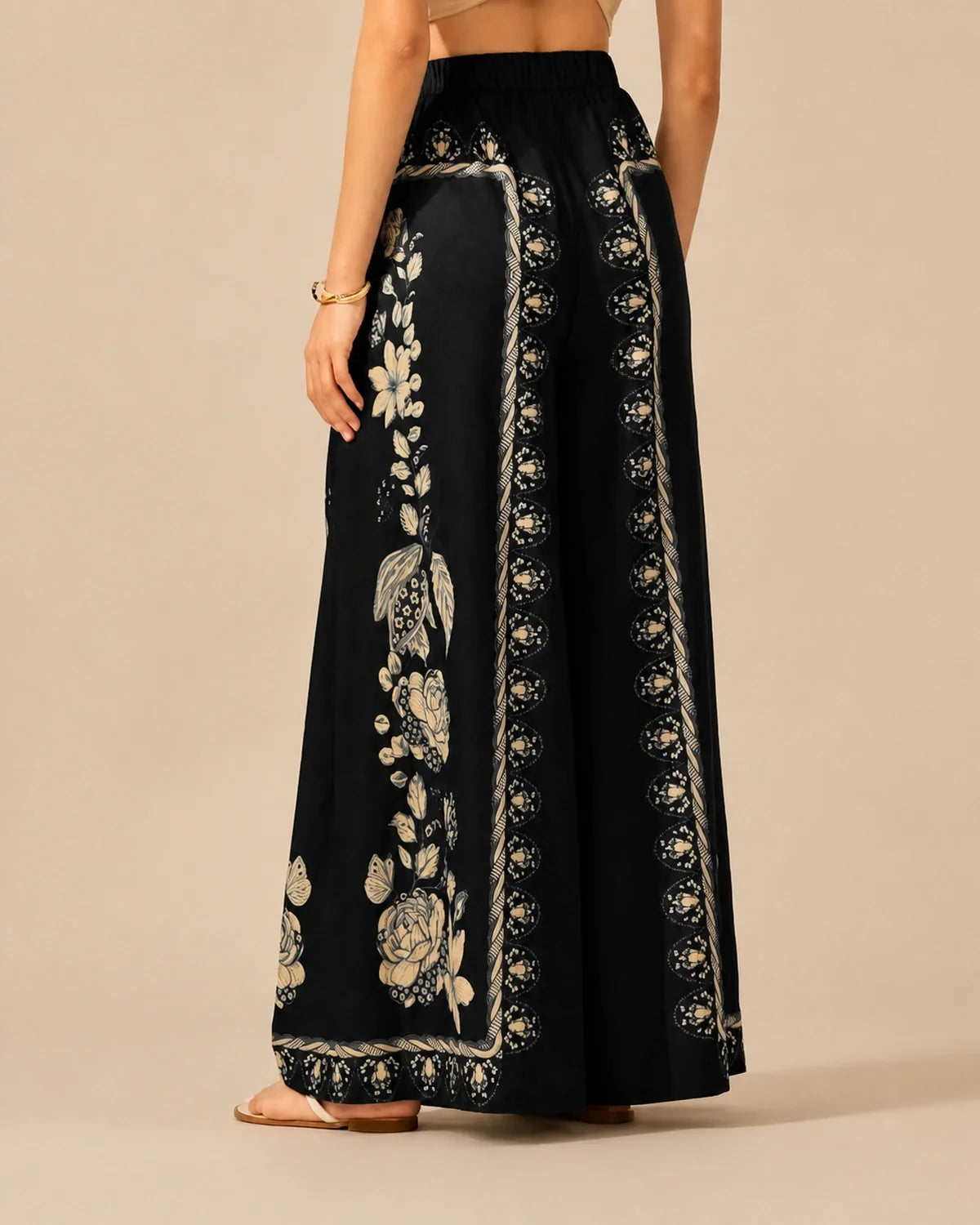 Rear view of black Floral Flow Pants with cream botanical panels