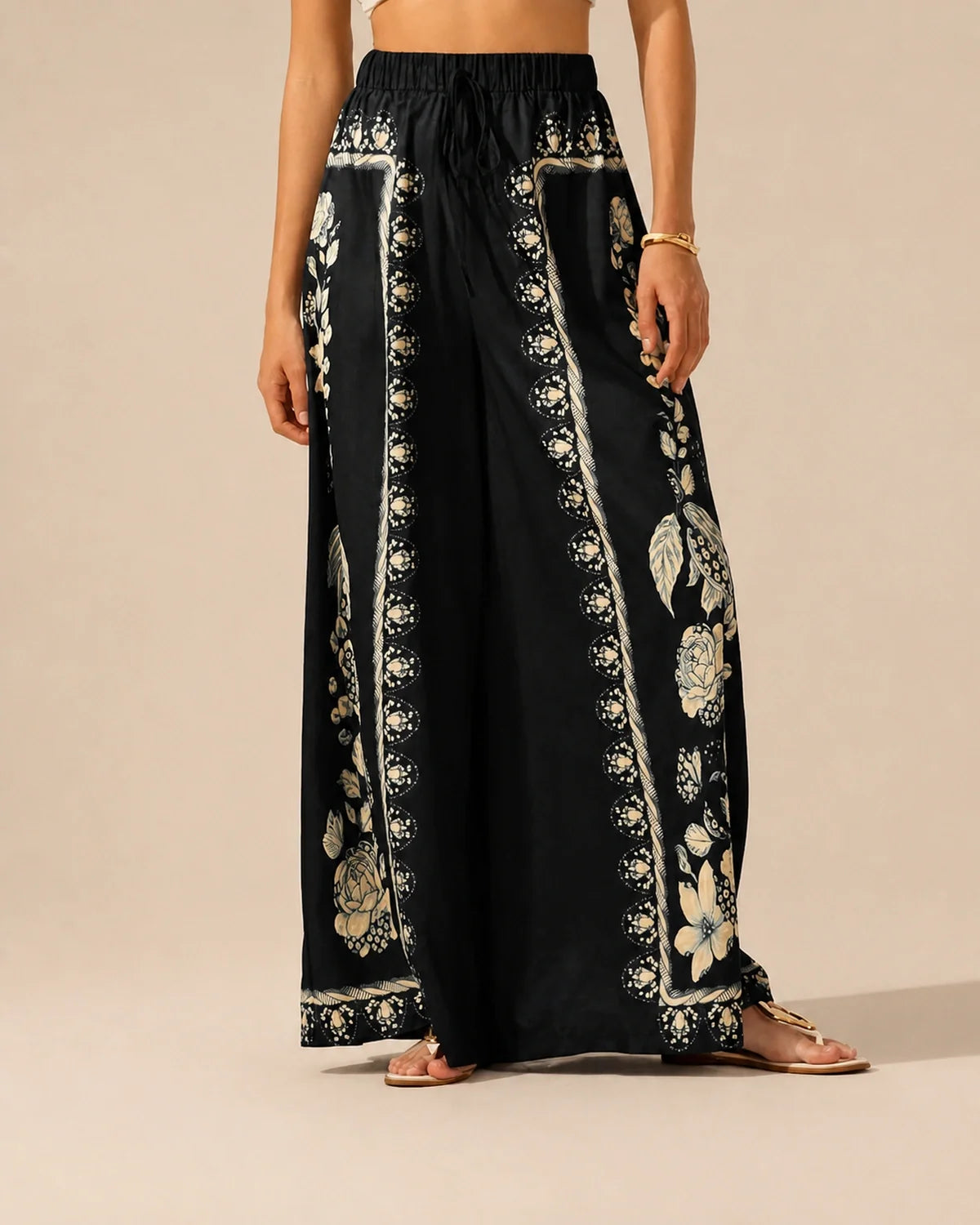 Model wearing black Floral Flow Pants in a warm studio front view