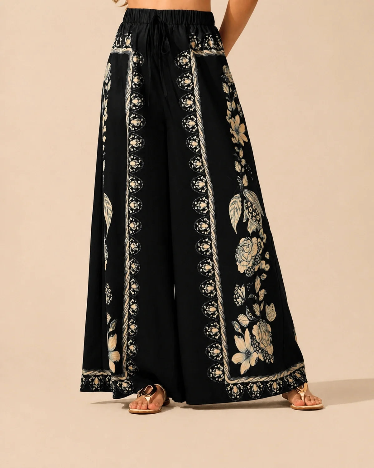 Front view of black wide-leg Floral Flow Pants with cream floral print