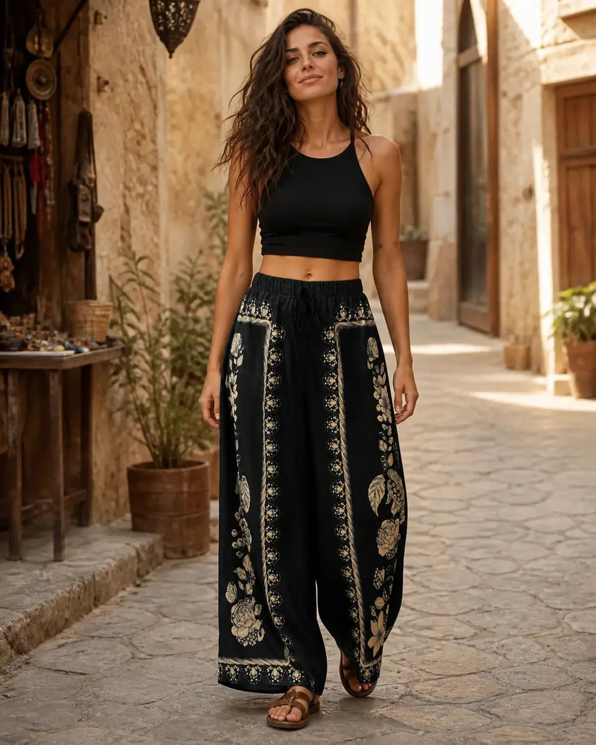Model wearing Floral Flow Pants in a sunlit stone street