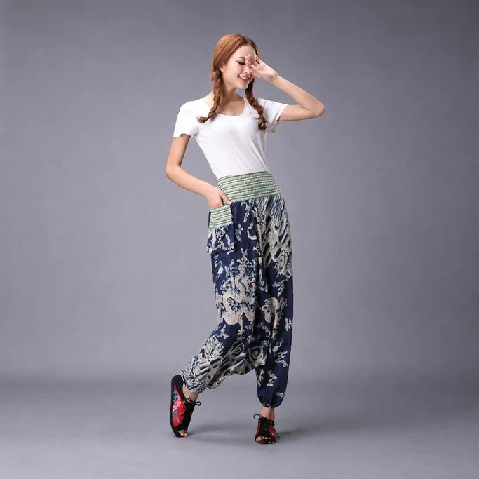 Model wearing blue Mythic Cloud Flow Harem Pants against a gray studio background