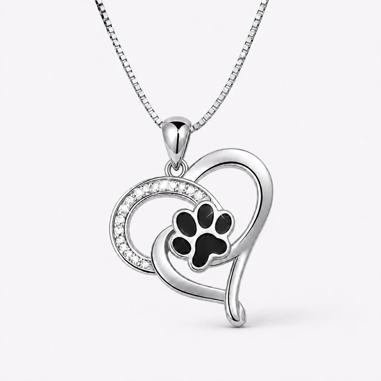 Pawprint Love Necklace with silver heart and black paw on a near-white studio background