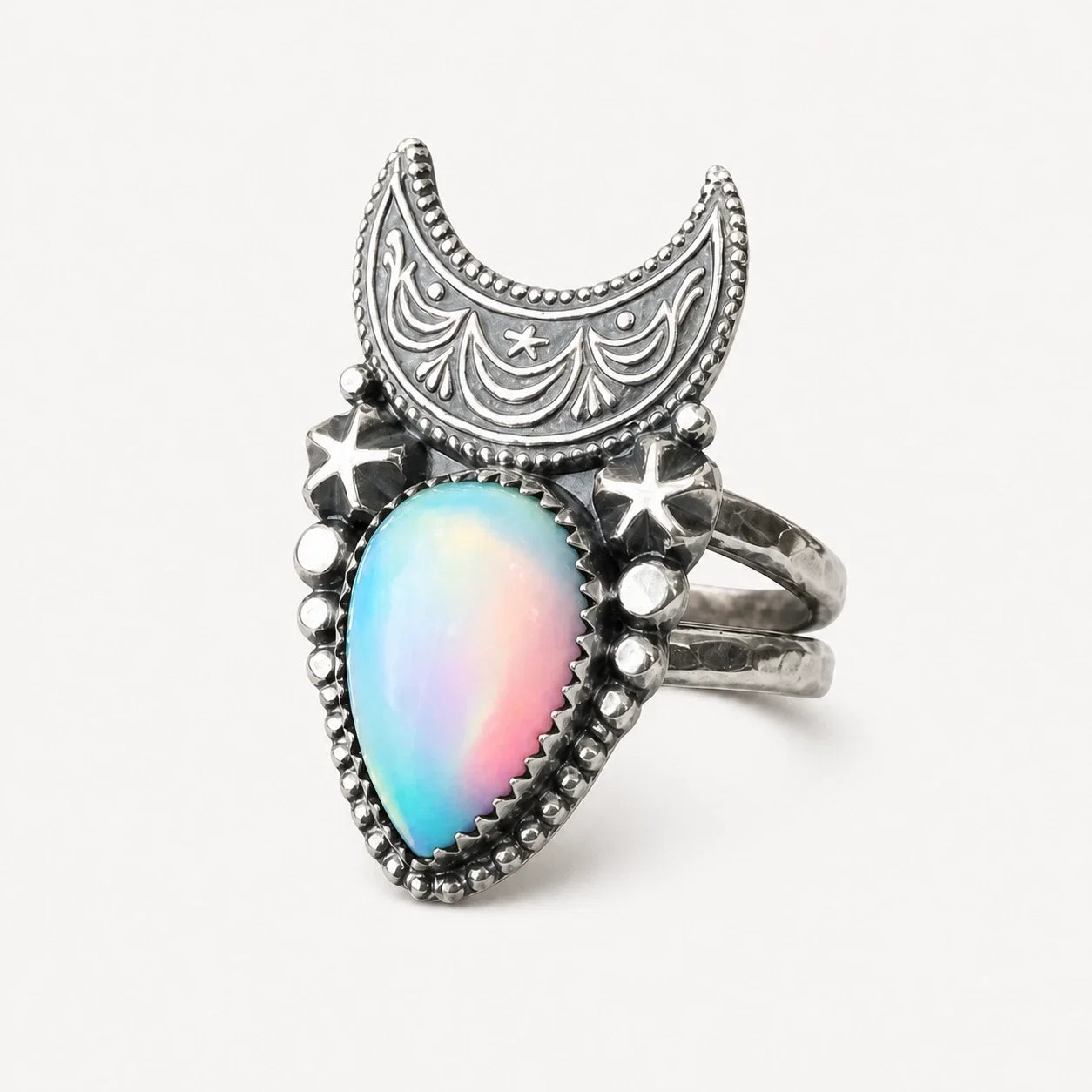 Supernova Crescent Moon Ring with luminous opal-style center on a warm white studio background
